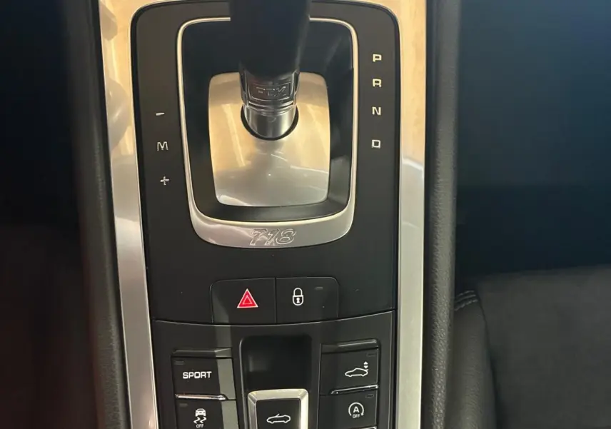 Gros plan sur la console centrale de la Porsche 718 Boxster noire, mettant en valeur le levier de vitesse automatique et les boutons de contrôle.