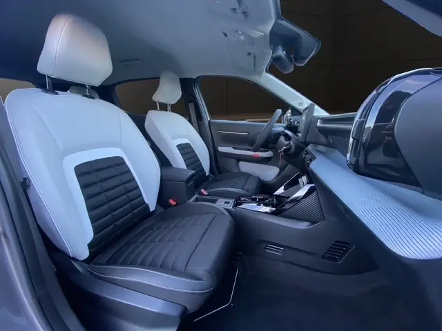Vue intérieure côté conducteur de la Citroën C3 Aircross 2026 hybride, sièges bicolores noirs et blancs, tableau de bord moderne.