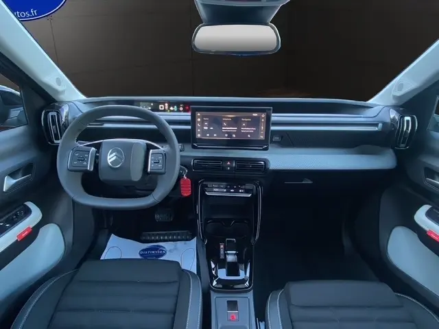 Vue intérieure avant du tableau de bord gris foncé du Citroën C3 Aircross hybride 2026 avec écran tactile central et volant multifonctions.