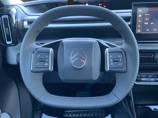 Vue frontale du volant cuir gris foncé du Citroën C3 Aircross hybride 2026, avec commandes multifonctions et tableau de bord numérique.