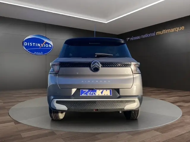Vue arrière d'un Citroën C3 Aircross gris foncé exposé en showroom, avec logo distinctif et plaque "Zero KM".