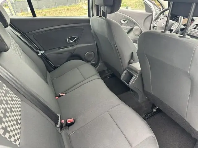 Vue intérieure arrière côté droit de la Renault Megane 3 gris, montrant les sièges tissu et les portes avec habillage sombre.