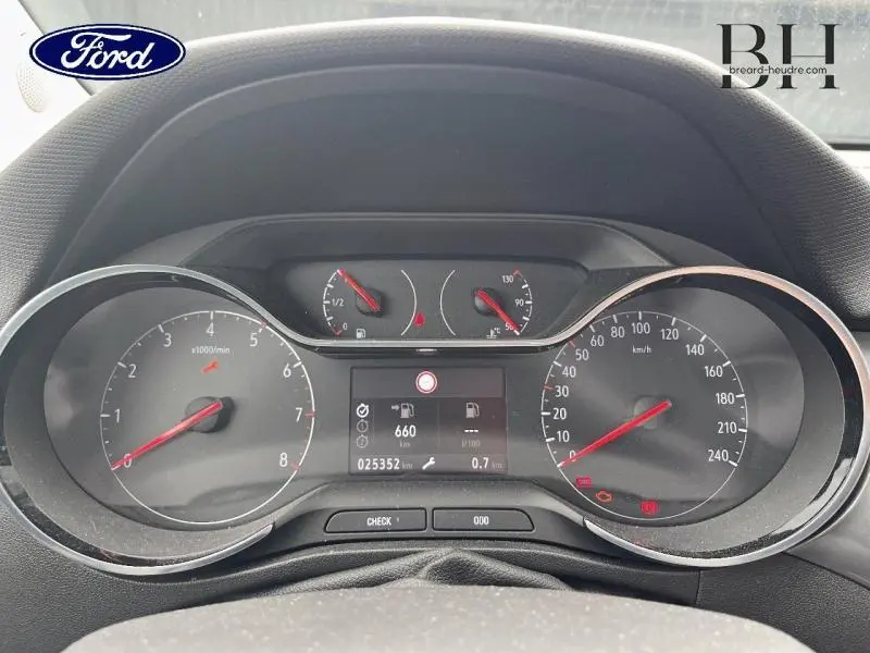 Vue rapprochée du tableau de bord d'une Opel Crossland 2023, affichage numérique et compteurs analogiques.
