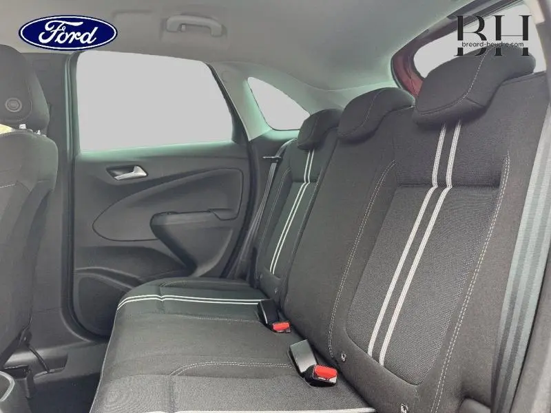 Vue intérieure du siège arrière côté gauche d'une Opel Crossland 2023 avec tissu noir à bandes blanches.
