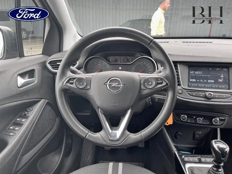 Vue intérieure centrée sur le volant cuir multifonction de l'Opel Crossland 2023 avec tableau de bord et écran tactile.