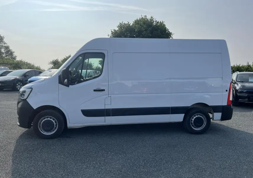 Profil côté gauche d'un Renault Master blanc 2023, fourgon utilitaire avec protections latérales noires et roues tôlées.