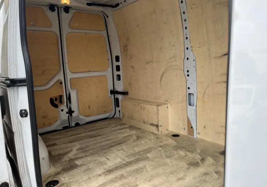 Vue intérieure arrière du Renault Master blanc 2023, montrant la zone de chargement avec plancher et protections latérales en bois.