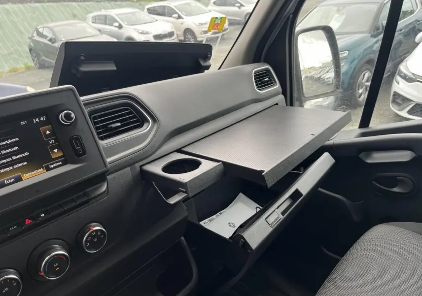 Intérieur côté passager du Renault Master blanc 2023, avec tablette rotative déployée et console ouverte.