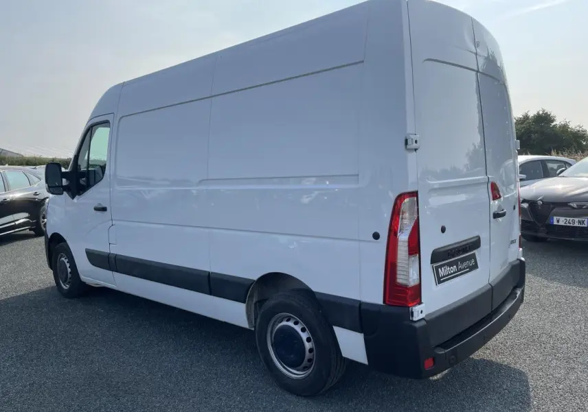 Renault Master blanc en vue 3/4 arrière droit, fourgon utilitaire avec protections latérales noires et roues tôlées.