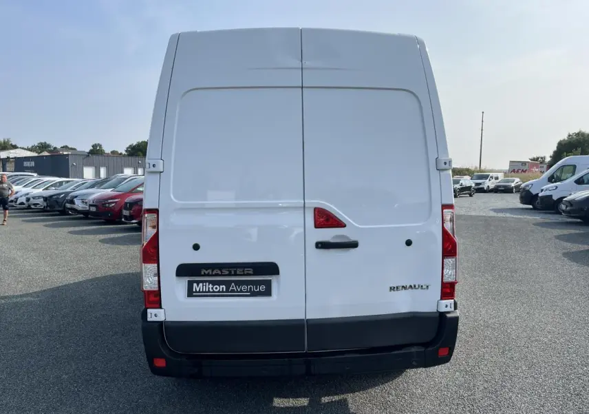 Vue arrière du Renault Master blanc avec portes battantes fermées et logo visible sur un parking extérieur.