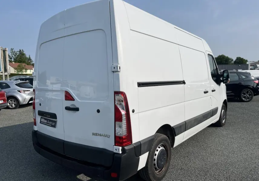 Renault Master blanc vu en 3/4 arrière droit, avec portes arrière tôlées et baguettes de protection noires.