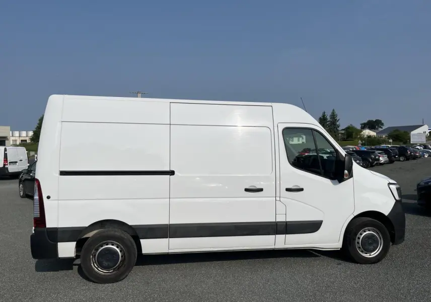 Renault Master blanc en vue profil côté gauche, fourgon utilitaire avec bande de protection noire et roues tôlées.