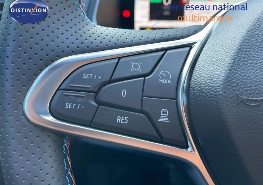 Gros plan sur les commandes de régulateur de vitesse au volant cuir perforé du Renault Captur E-Tech hybride 2025.