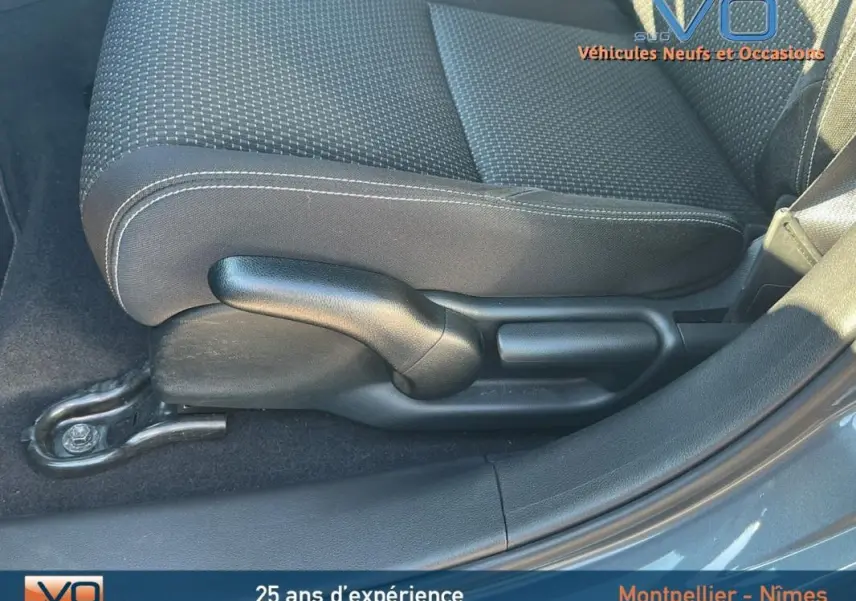 Gros plan sur la commande de réglage manuel du siège avant droit d'une Honda Civic gris 2015, tissu noir à surpiqûres blanches.