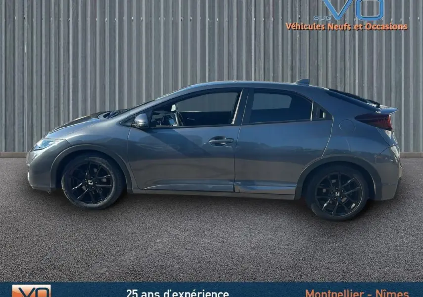 Profil côté gauche d'une Honda Civic 1.6 i-DTEC 120 Elegance gris 2015 avec jantes alliage noires et vitres surteintées.