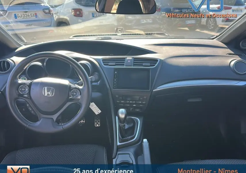 Vue intérieure avant de la Honda Civic 1.6 i-DTEC 120 Elegance 2015 avec volant multifonction et boîte manuelle.