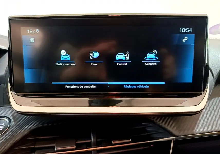Écran tactile central affichant les réglages véhicule dans l'habitacle d'une Peugeot 208 gris foncé, vue de face rapprochée.