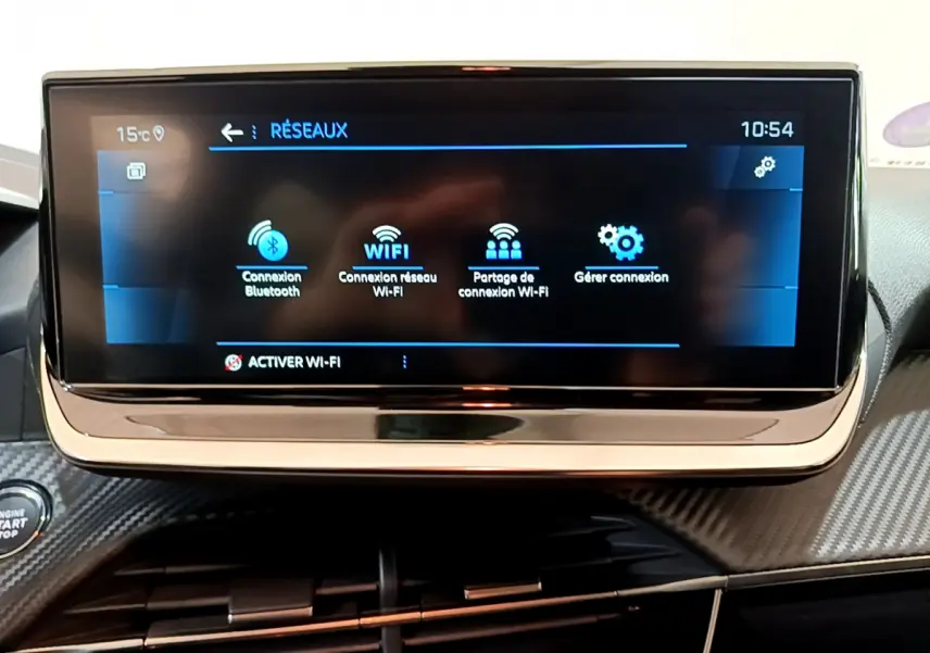 Écran tactile central affichant les options réseau dans l'habitacle d'une Peugeot 208 gris foncé 2022.