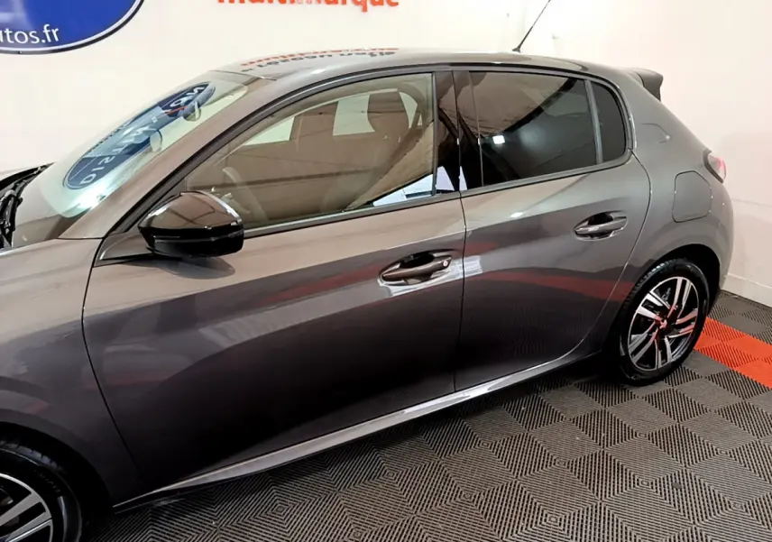 Profil côté gauche d'une Peugeot 208 gris foncé 2022 avec rétroviseurs noirs et jantes alliage distinctives.