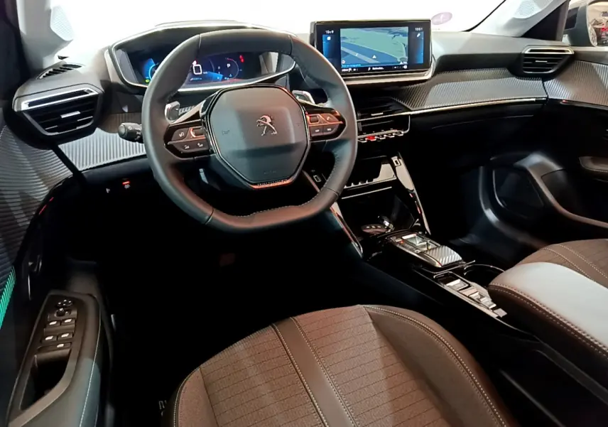Intérieur Peugeot 208 2022 vue côté conducteur, volant cuir, écran tactile 10 pouces et sellerie tissu gris foncé.