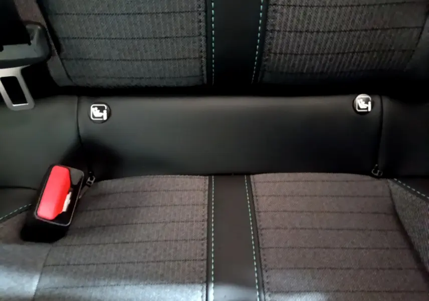 Gros plan sur la banquette arrière gris foncé de la Peugeot 208 avec coutures bleues et fixations Isofix visibles