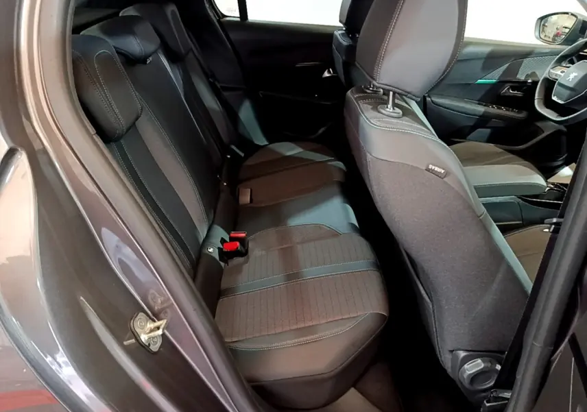 Vue intérieure côté gauche montrant les sièges arrière en tissu noir et gris du Peugeot 208 gris foncé 2022 Allure Pack.