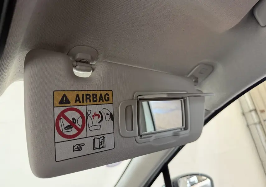 Détail du pare-soleil côté conducteur avec miroir intégré et avertissement airbag dans une Renault Clio blanche 2023.