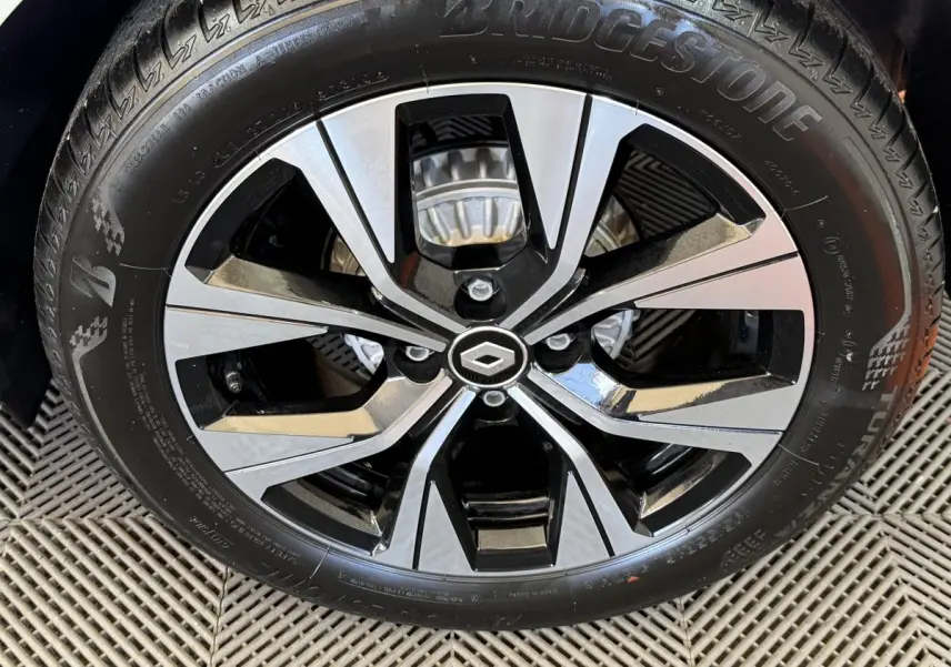 Gros plan sur la jante alliage bicolore noir et argent avec logo Renault au centre, montée sur pneu Bridgestone.