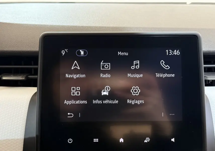 Écran tactile central de la Renault Clio Business blanc, affichant le menu principal avec navigation et radio.