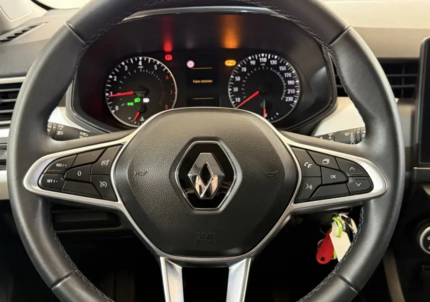 Vue rapprochée du volant cuir noir de la Renault Clio Business TCe 100 GPL 2023 avec tableau de bord et commandes intégrées.