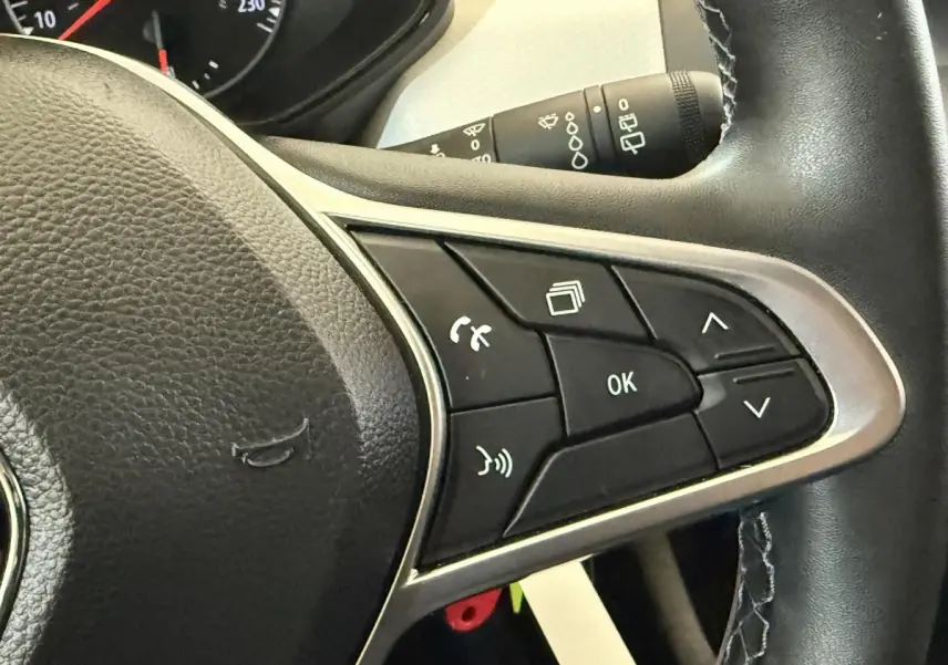 Gros plan sur les commandes multifonctions à droite du volant cuir noir de la Renault Clio Business TCe 100 GPL 2023.