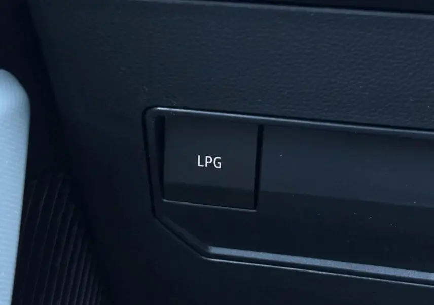 Gros plan sur le bouton LPG noir dans l'habitacle du Dacia Duster Gris Schiste, version ECO-G 120 Auto Extrême.
