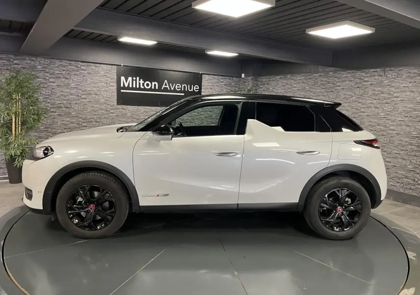 Vue latérale gauche d'un DS3 Crossback 2022 bi-ton blanc et noir avec jantes noires et badges Performance Line visibles.