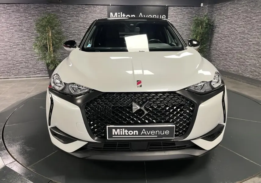 Vue frontale d'un DS3 Crossback 2022 bi-ton blanc et noir avec calandre noire texturée et logo DS central.