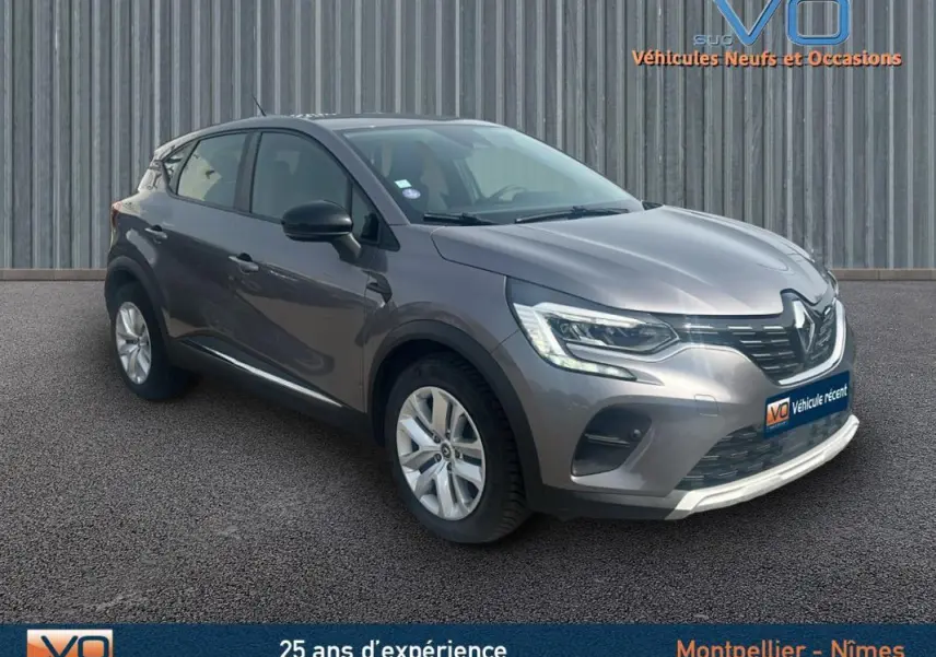 Renault Captur TCe 100 Business gris vu en 3/4 avant droit, avec phares LED et jantes alliage visibles.