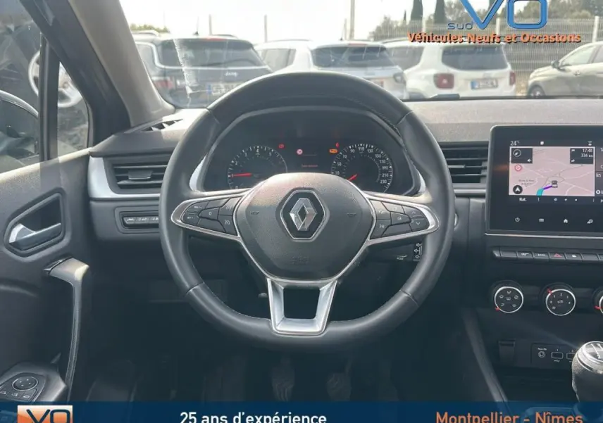 Vue intérieure centrée sur le volant d'un Renault Captur gris 2020 avec tableau de bord et écran tactile visible.
