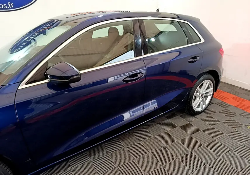 Vue latérale côté gauche d'une Audi A3 bleu profond, mettant en valeur les lignes élégantes et les jantes alliage.