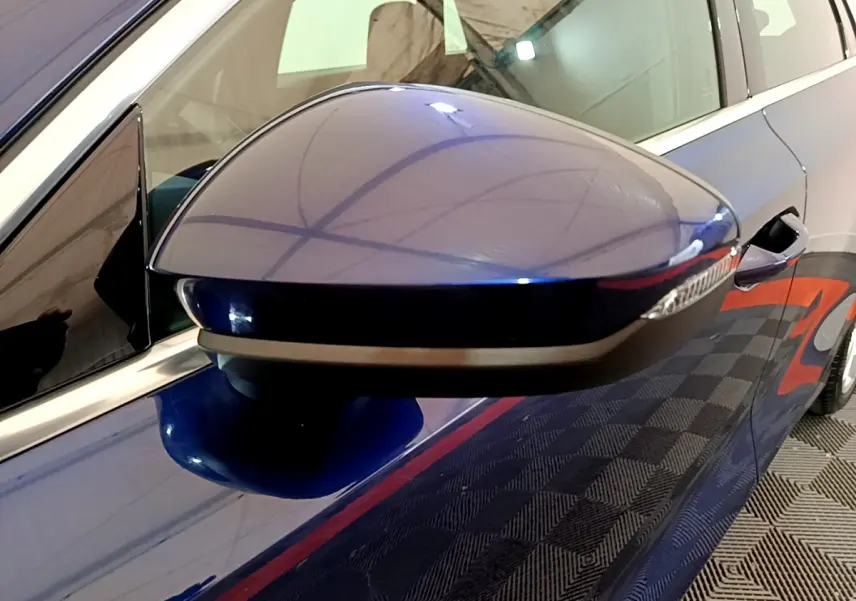 Rétroviseur côté gauche bleu brillant de l'Audi A3 35 TFSI 150 MHEV Business Line 2023 avec clignotant intégré.