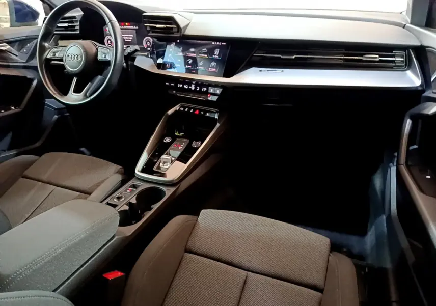 Intérieur noir de l'Audi A3 35 TFSI 2023 vu côté conducteur, avec tableau de bord numérique et console centrale moderne.