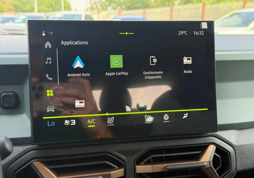 Écran tactile central du tableau de bord du Dacia Duster gris, affichant les applications Android Auto et Apple CarPlay.