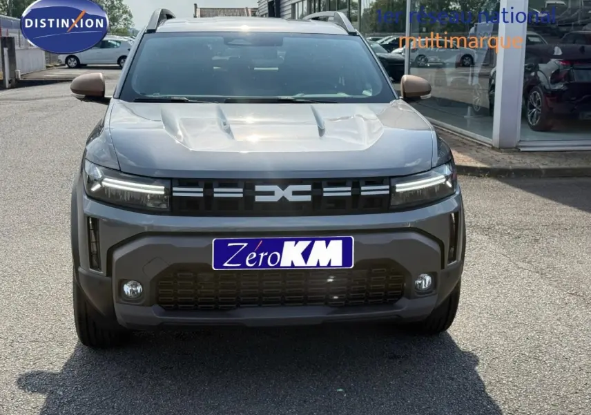 Vue avant d'un Dacia Duster gris 2026 avec calandre noire et feux LED horizontaux allumés.