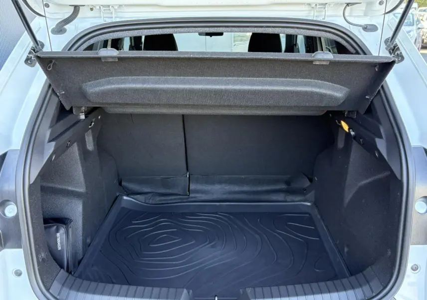 Coffre ouvert du Dacia Duster Blanc Glacier 2026, vue arrière montrant l'espace de chargement et la housse de protection.