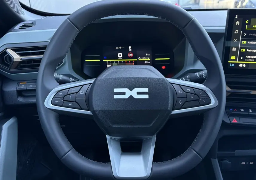 Vue centrée sur le volant noir du Dacia Duster 2026 avec tableau de bord digital et écran tactile latéral.