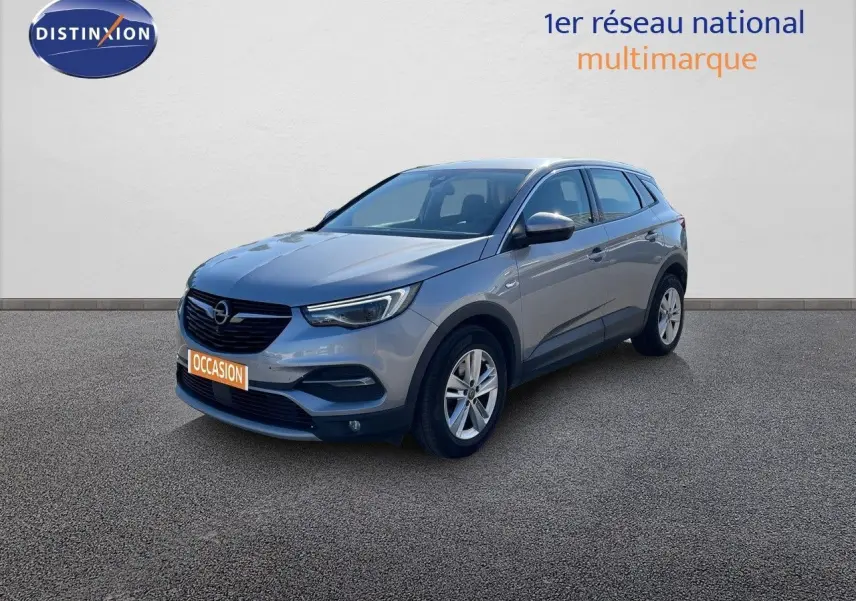 Opel Grandland X gris quartz métal en 3/4 avant droit, SUV compact avec jantes alliage et calandre noire.
