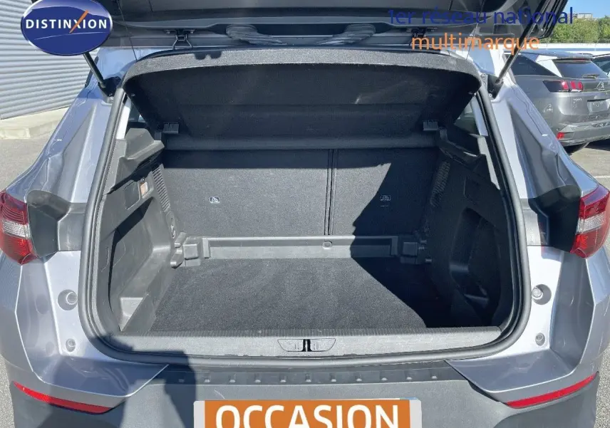 Coffre ouvert d'un Opel Grandland X gris quartz métal, vue arrière mettant en valeur l'espace de chargement vide.