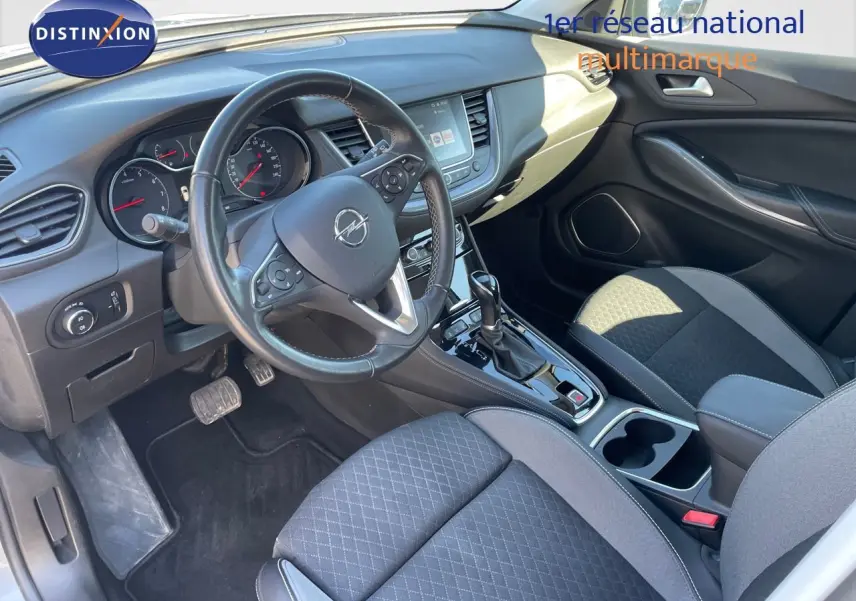 Intérieur de l'Opel Grandland X 2021 en vue côté conducteur, avec tableau de bord noir et sièges tissu gris et noir.