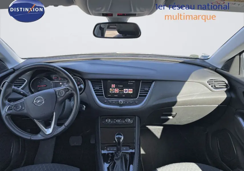 Intérieur de l'Opel Grandland X 2021 vu de face, tableau de bord noir avec écran central et volant multifonction.