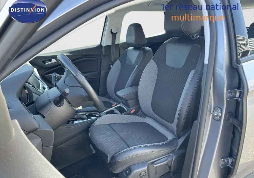 Intérieur avant droit de l'Opel Grandland X gris quartz, sièges tissu et cuir noir avec volant et console visibles.