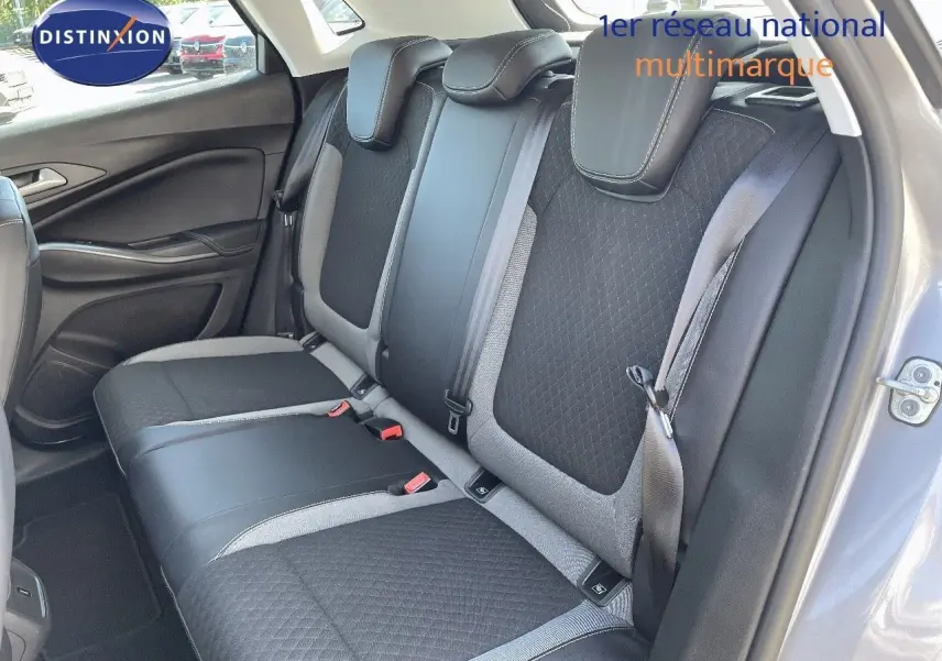 Vue intérieure arrière droite des sièges arrière en tissu noir et gris d'un Opel Grandland X gris quartz métal.