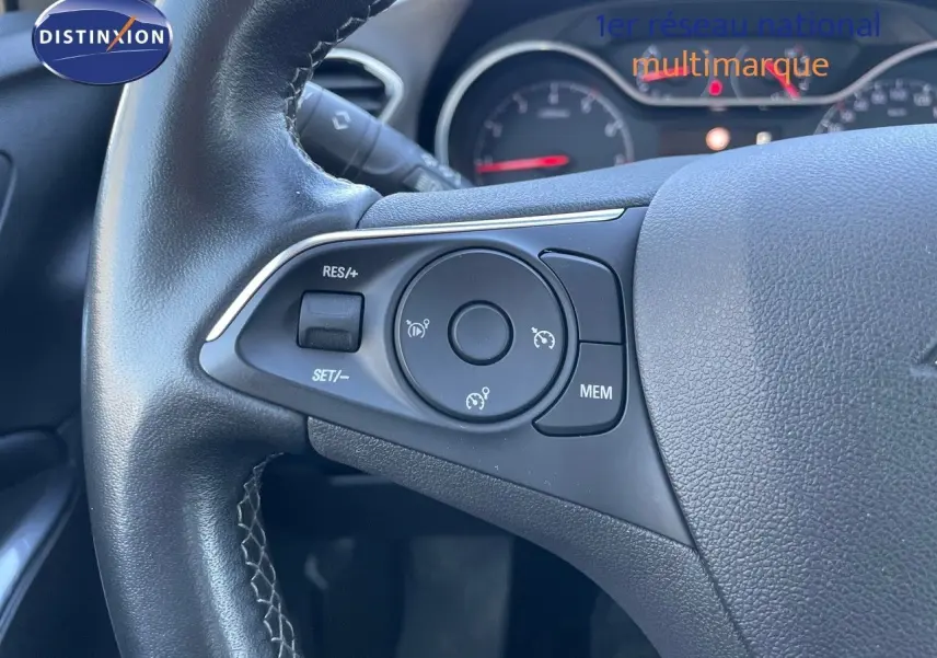 Gros plan sur le volant noir de l'Opel Grandland X 2021, montrant les commandes de régulateur de vitesse.